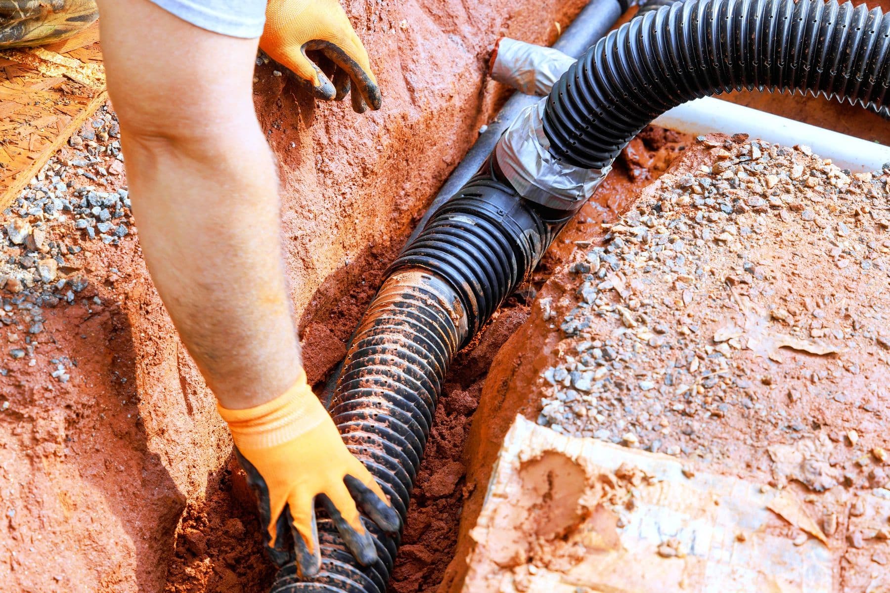 French drain pipe installation in East Texas clay soil
